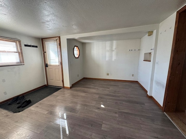 entrance foyer featuring a textured ceiling, wood finished floors, and baseboards