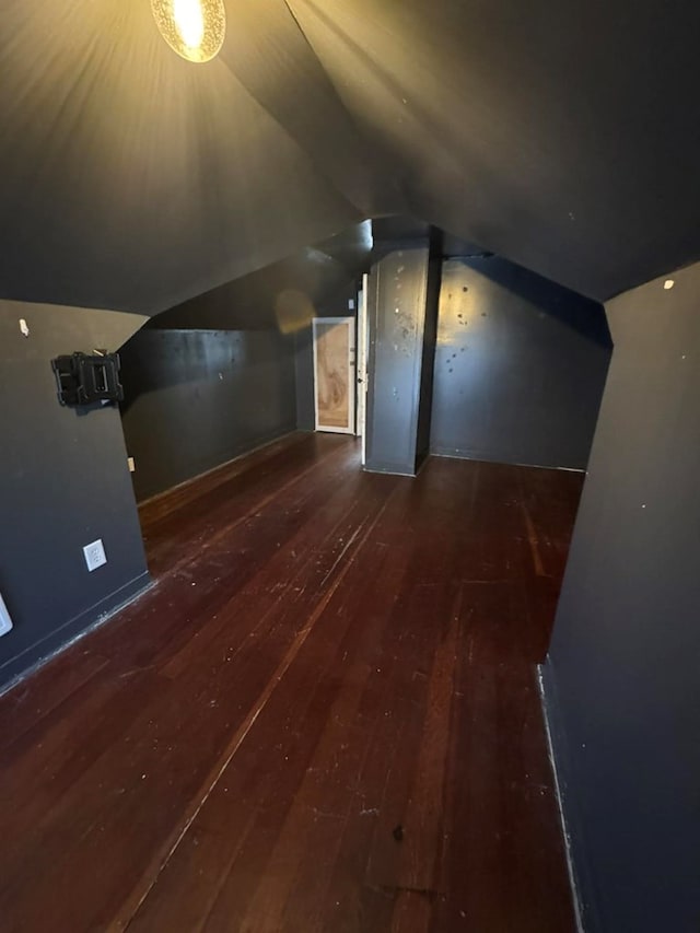 additional living space featuring vaulted ceiling and wood-type flooring