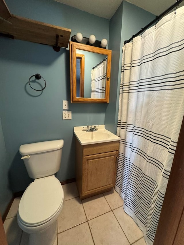 bathroom with baseboards, vanity, toilet, and tile patterned floors