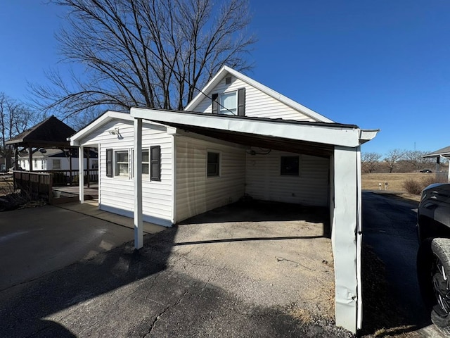 exterior space with aphalt driveway and an attached carport