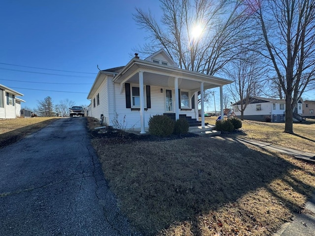 view of front of property with a porch, a chimney, and aphalt driveway