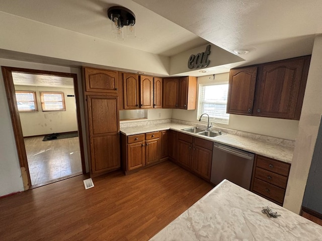 kitchen with a sink, dark wood-style flooring, dishwasher, and light countertops