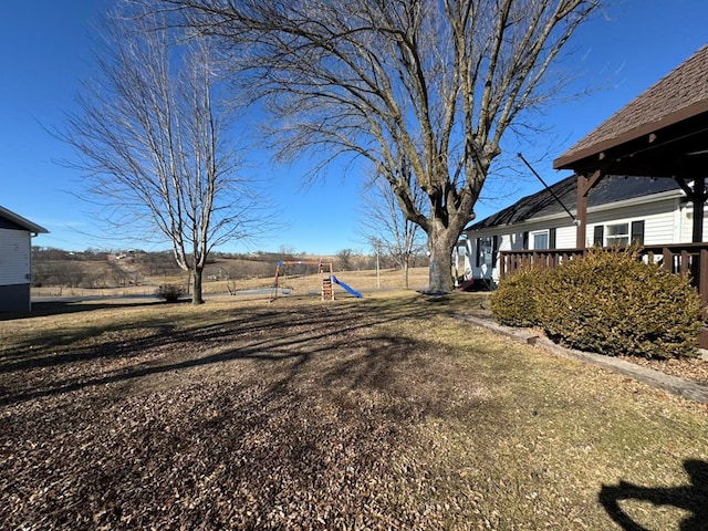 view of yard with a playground and a wooden deck