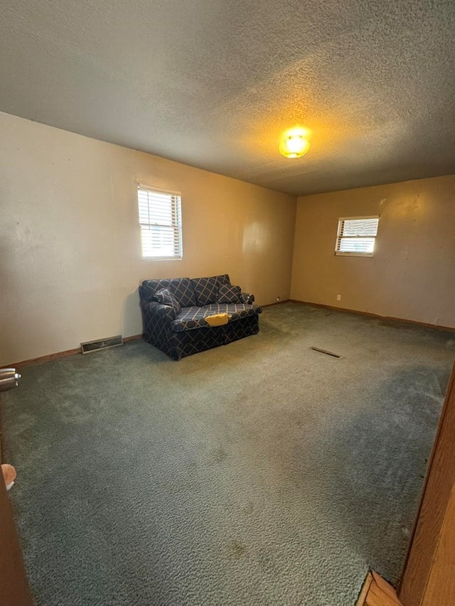 living area with carpet, visible vents, and a wealth of natural light