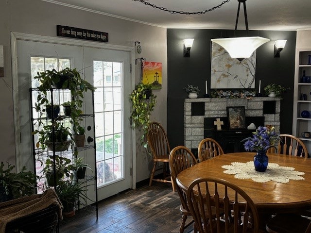 2 Center Dr, Kirksville, MO 63501 - dining area featuring dark wood-style flooring, a stone fireplace, crown molding, and a healthy amount of sunlight
