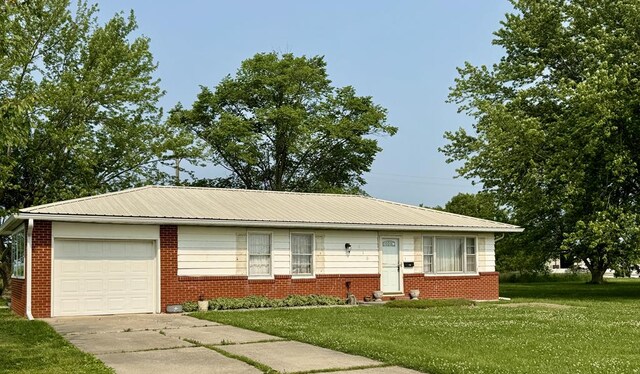 810 S W St, Green City, MO 63545 - view of front facade with a garage, brick siding, a front lawn, and metal roof