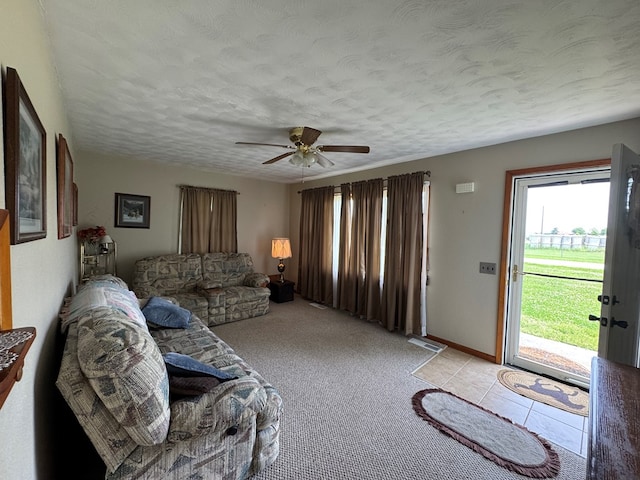 810 S W St, Green City, MO 63545 - living area with a textured ceiling, ceiling fan, light tile patterned floors, baseboards, and light carpet