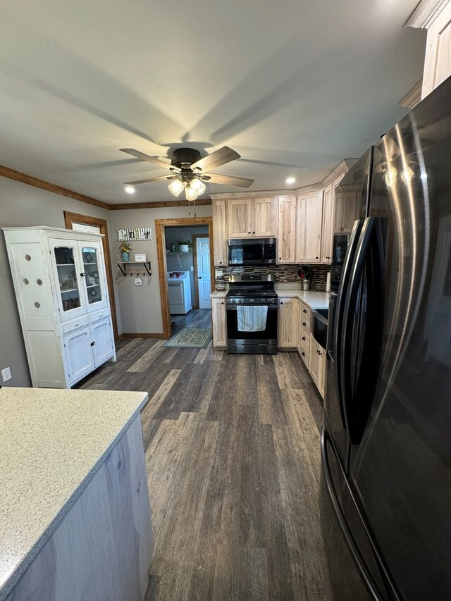 kitchen with washer / dryer, a breakfast bar area, hanging light fixtures, dark hardwood / wood-style flooring, and kitchen peninsula