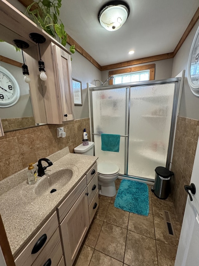 bathroom featuring tile walls, vanity, walk in shower, toilet, and tile patterned floors