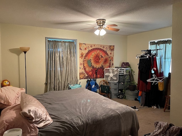 carpeted bedroom with a textured ceiling and ceiling fan