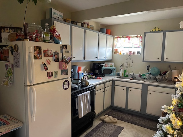 kitchen featuring black electric range, white refrigerator, and white cabinets