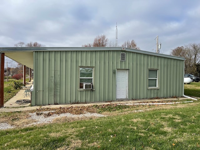 view of outdoor structure featuring cooling unit and a lawn