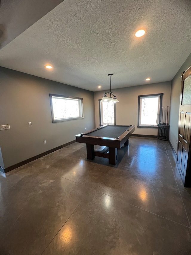 playroom with baseboards, a healthy amount of sunlight, and finished concrete floors