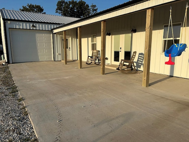 view of patio with a garage, an outdoor structure, and french doors