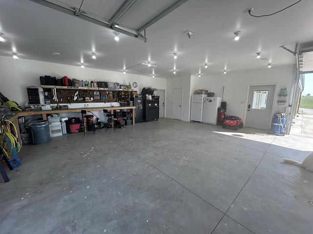 garage featuring a workshop area and white refrigerator