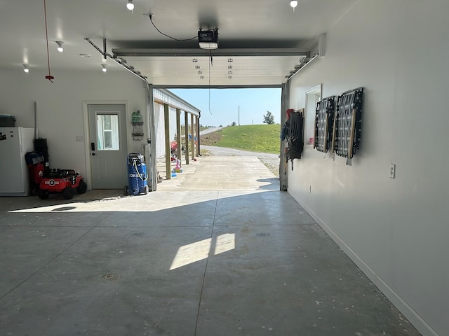 garage with white refrigerator and a garage door opener