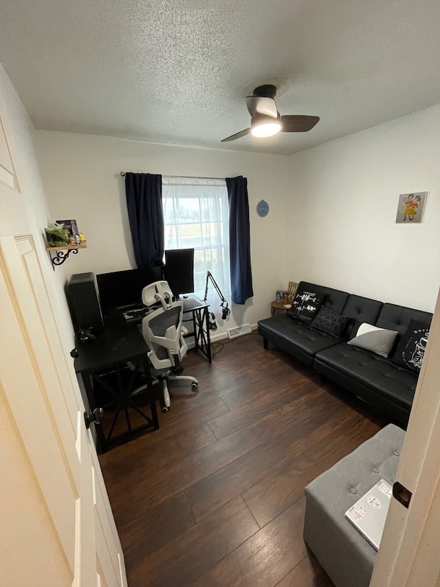 home office featuring ceiling fan, wood finished floors, and a textured ceiling