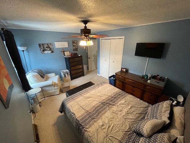 carpeted bedroom with ceiling fan, a closet, and a textured ceiling