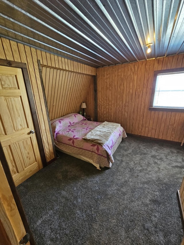 bedroom with wood walls and dark colored carpet