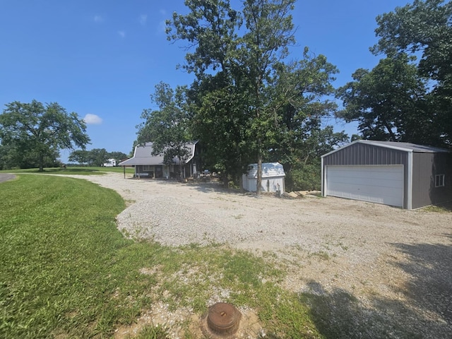 view of yard with a storage shed, a garage, and a carport