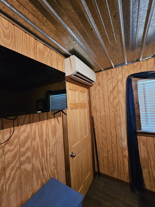 interior space featuring dark hardwood / wood-style flooring, an AC wall unit, and wood walls