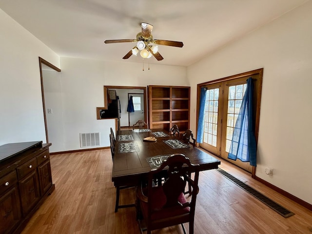 dining area with light wood finished floors, baseboards, and visible vents