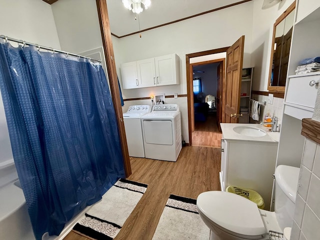 full bath with curtained shower, toilet, wood finished floors, vanity, and washer and dryer