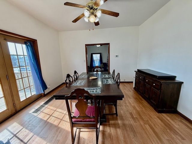 dining room with light wood finished floors, baseboards, visible vents, and ceiling fan