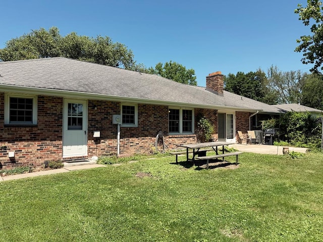 1921 First St, Kirksville, MO 63501 - back of house with a chimney, a lawn, a patio area, and brick siding