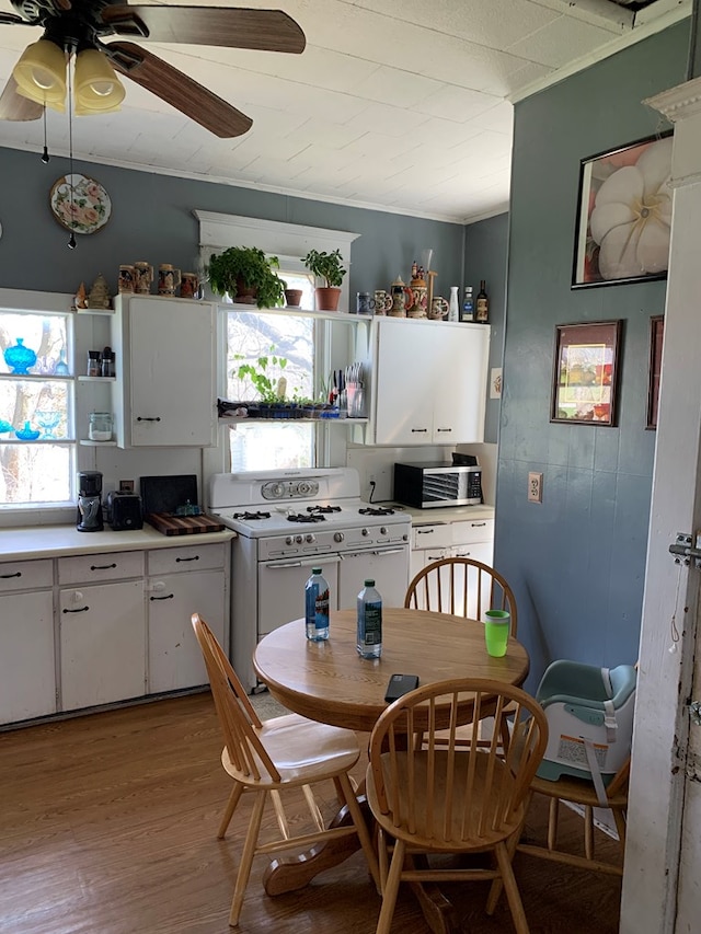 704 N Fourth St, Edina, MO 63537 - kitchen featuring crown molding, white cabinets, light wood finished floors, open shelves, and white gas stove