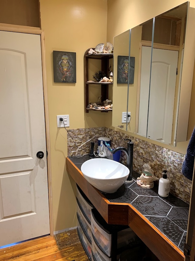 704 N Fourth St, Edina, MO 63537 - bathroom with wood finished floors, decorative backsplash, and vanity
