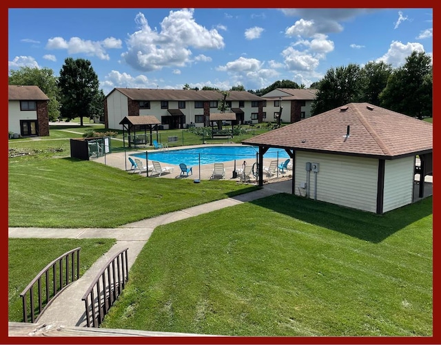 view of swimming pool with a yard