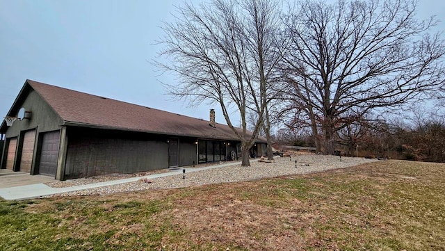 view of side of home with a lawn and a garage