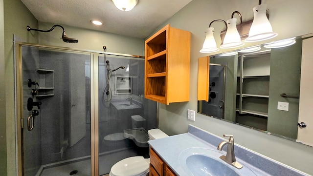 bathroom featuring vanity, a textured ceiling, toilet, and a shower with shower door