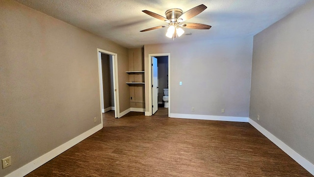 unfurnished bedroom featuring ceiling fan, dark hardwood / wood-style flooring, a textured ceiling, and connected bathroom