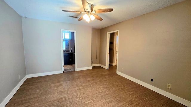 empty room featuring a textured ceiling, dark hardwood / wood-style floors, and ceiling fan