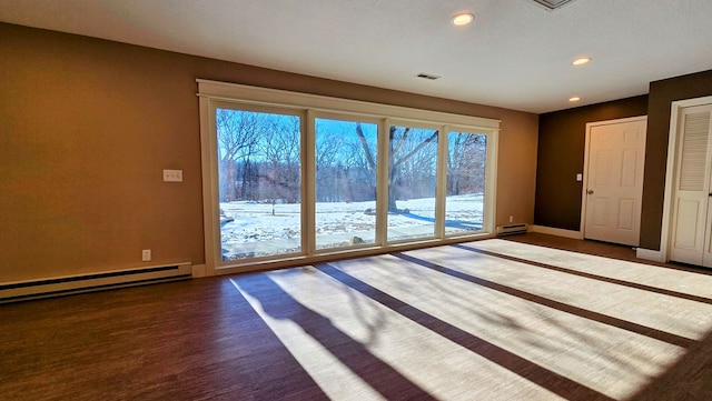 doorway to outside featuring hardwood / wood-style floors and a baseboard heating unit