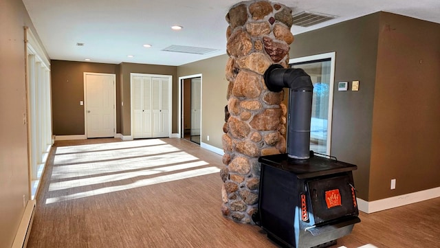 corridor with wood-type flooring and baseboard heating