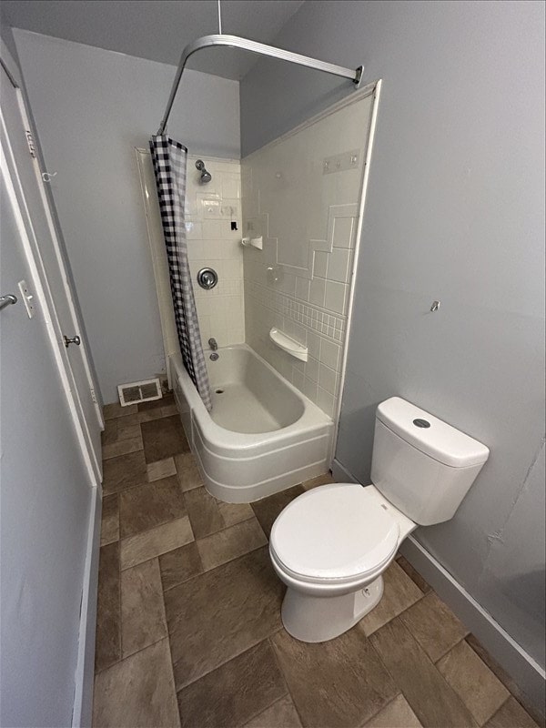 bathroom featuring shower / tub combo with curtain and toilet