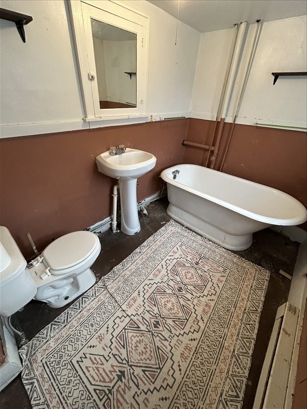 bathroom featuring toilet, sink, and a washtub