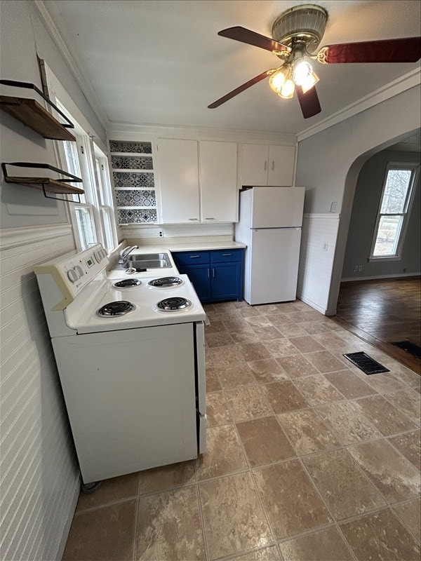 kitchen with blue cabinets, sink, white cabinets, crown molding, and white appliances