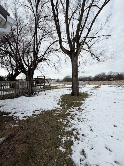 yard layered in snow with a playground