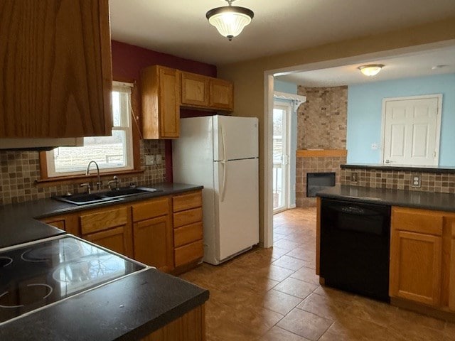 kitchen featuring sink, dishwasher, white refrigerator, tasteful backsplash, and a fireplace