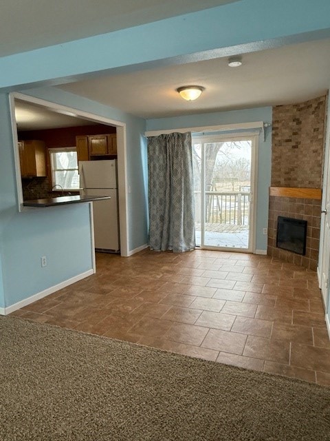 unfurnished living room with carpet and a fireplace