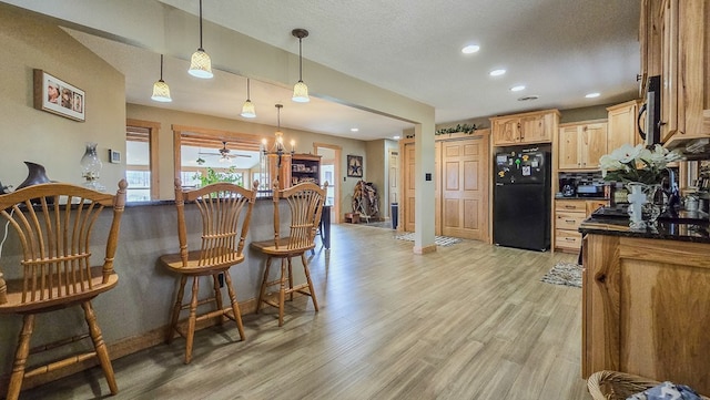 26831 State Highway 11, Kirksville, MO 63501 - kitchen with baseboards, dark countertops, decorative light fixtures, light wood-style floors, and freestanding refrigerator