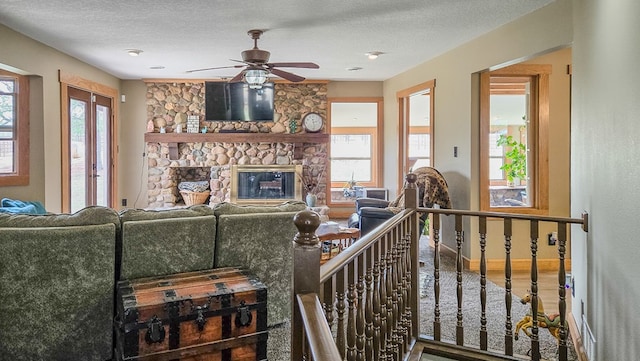 26831 State Highway 11, Kirksville, MO 63501 - living room featuring a fireplace, wood finished floors, a textured ceiling, baseboards, and ceiling fan