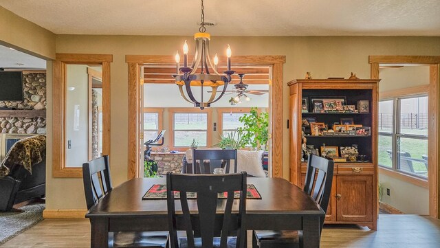 26831 State Highway 11, Kirksville, MO 63501 - dining room featuring an inviting chandelier, light wood-style flooring, a fireplace, and a textured ceiling