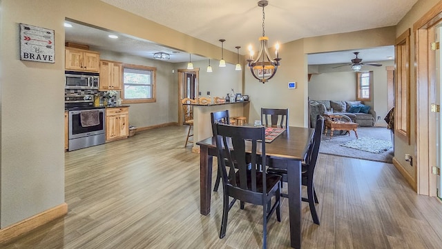 26831 State Highway 11, Kirksville, MO 63501 - dining area with light wood-style flooring, ceiling fan with notable chandelier, and baseboards