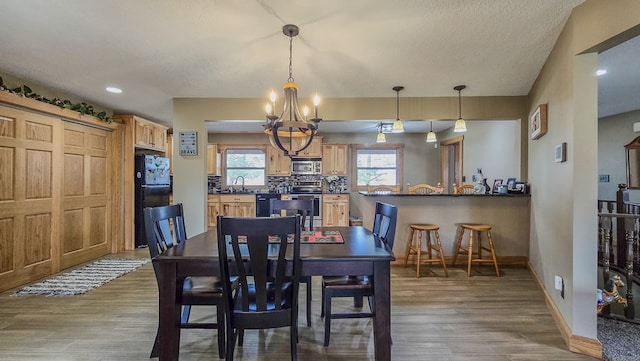 26831 State Highway 11, Kirksville, MO 63501 - dining space featuring a textured ceiling, baseboards, wood finished floors, and a chandelier