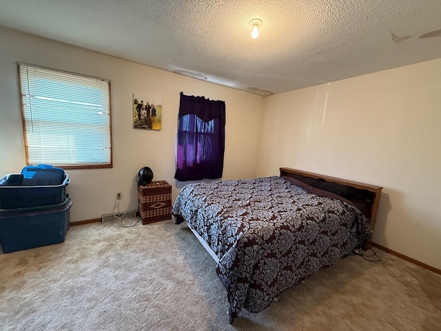bedroom with a textured ceiling, baseboards, and carpet floors